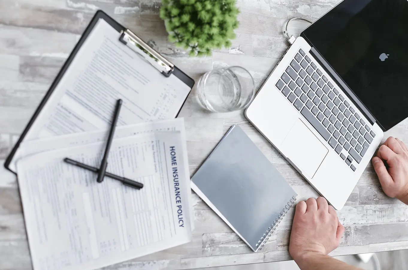 Top view of home loan documents, laptop, and forms on a desk for mortgage rate research