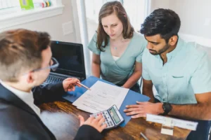 Young couple meeting with a real estate agent about an ARM mortgage meaning and home purchase