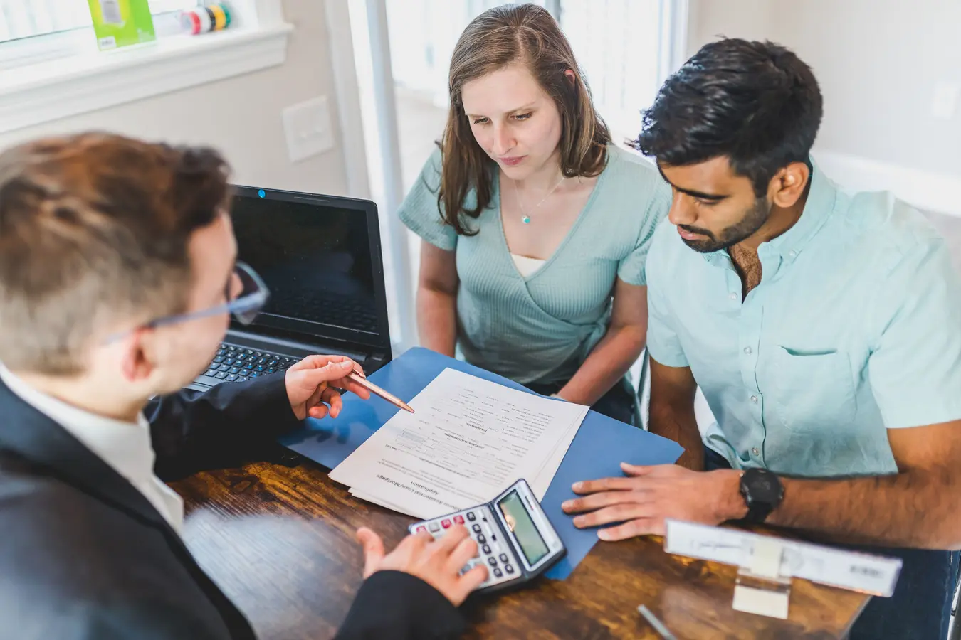 Young couple meeting with a real estate agent about an ARM mortgage meaning and home purchase
