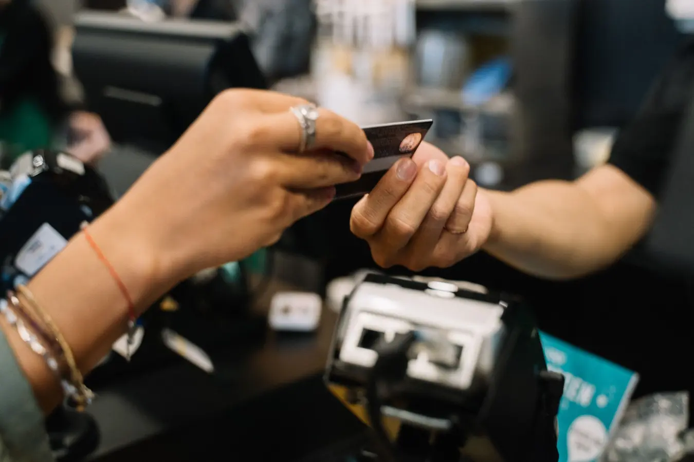 Hands using a bank card at a retail checkout, relevant to golf credit cards in India