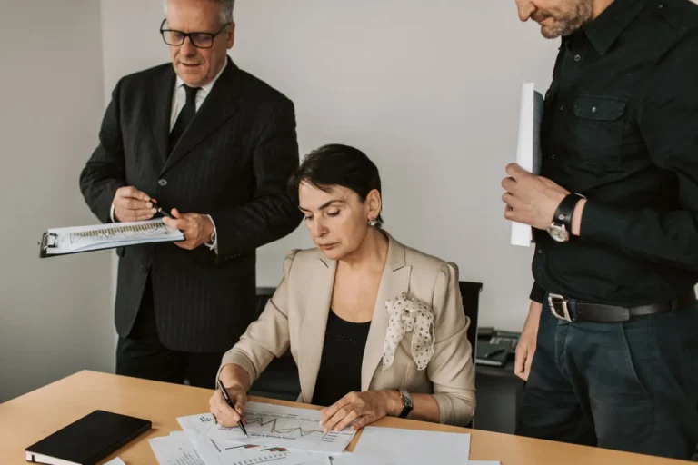 Business professionals reviewing financial documents in an office, discussing project management software options