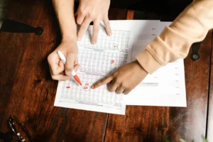 Hands reviewing and marking financial documents with a red pen, illustrating bond intrinsic value formula analysis