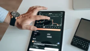 Person analyzing market trends on a tablet displaying digital charts and financial data