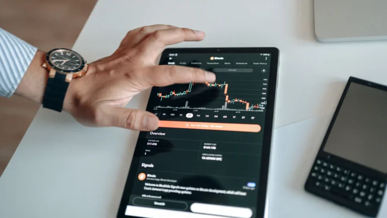 Person analyzing market trends on a tablet displaying digital charts and financial data