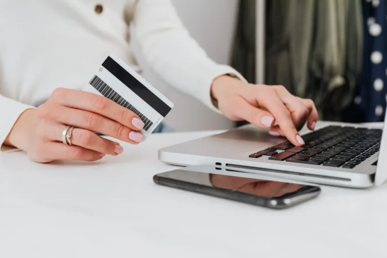 Woman using a credit card on a laptop for an online Capital One credit cards transaction