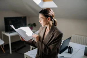 Professional woman reviewing financial documents at her office desk for ESG investing research