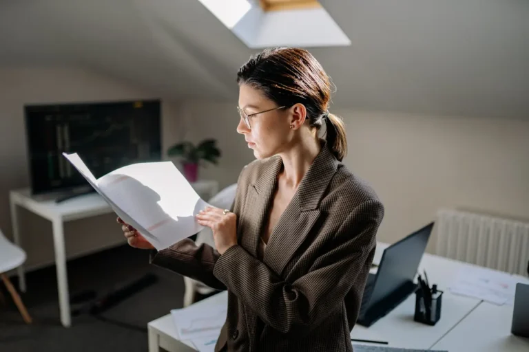 Professional woman reviewing financial documents at her office desk for ESG investing research