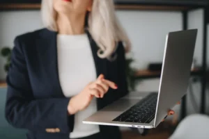 Senior businesswoman using a laptop in a modern office while reviewing password management options