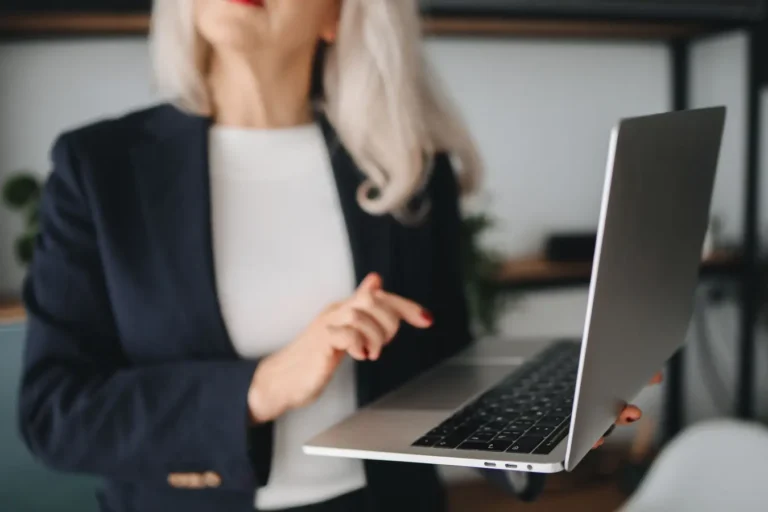 Senior businesswoman using a laptop in a modern office while reviewing password management options