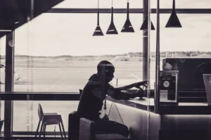 Person sitting in an airport lounge overlooking the runway, relevant to Canada credit cards with lounge access