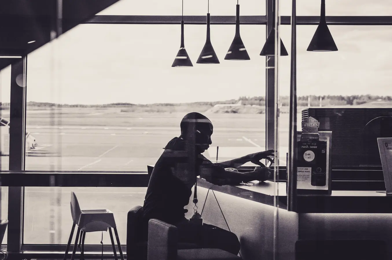 Person sitting in an airport lounge overlooking the runway, relevant to Canada credit cards with lounge access