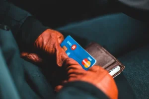Gloved hands holding a credit card and wallet indoors while comparing credit cards from American Express