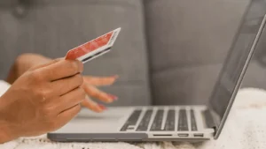Person using a credit card for online shopping on a laptop, relevant to Amazon purchases