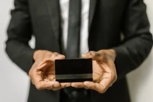 Businessman holding a blank credit card, illustrating credit cards with travel perks