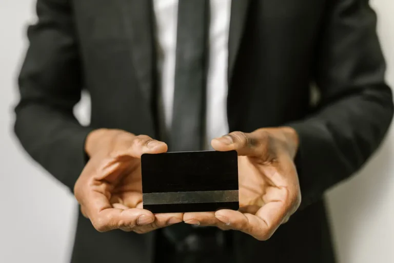 Businessman holding a blank credit card, illustrating credit cards with travel perks