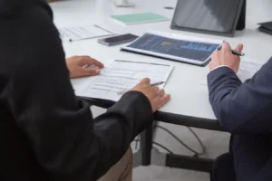 Professionals reviewing analytics documents in an office, discussing CRM and ERP software examples