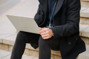 Anonymous male office employee in formal wear using a netbook on outdoor stairs