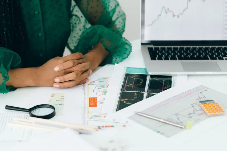 Person reviewing financial charts at a desk for quick forex trading profit calculator checks