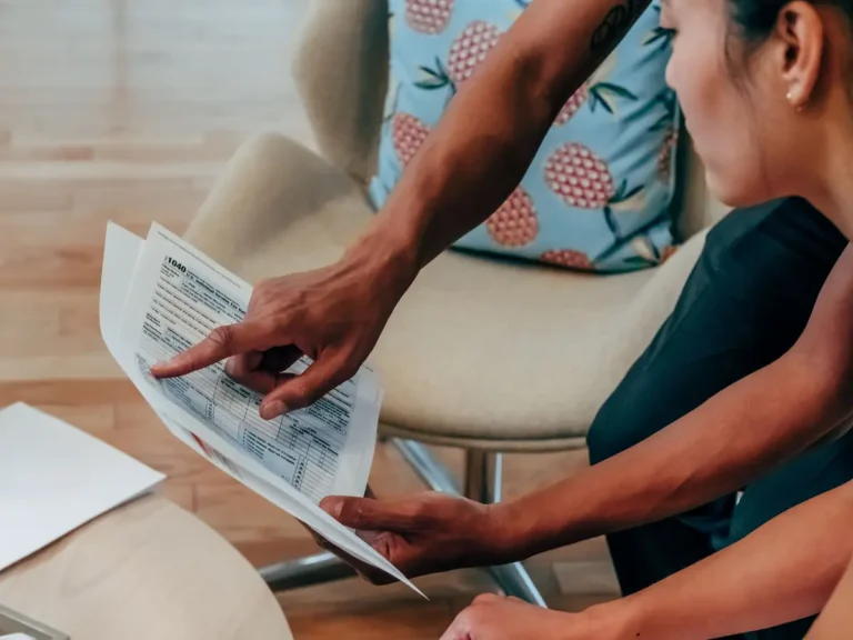 Two people reviewing financial documents closely for an FSA vs health savings account comparison