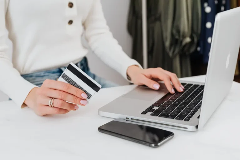 Person using a laptop for online shopping while holding a credit card