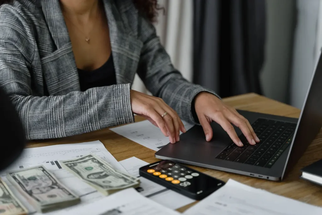 Businesswoman managing finances with cash and calculator, relevant to a health savings account HSA bank