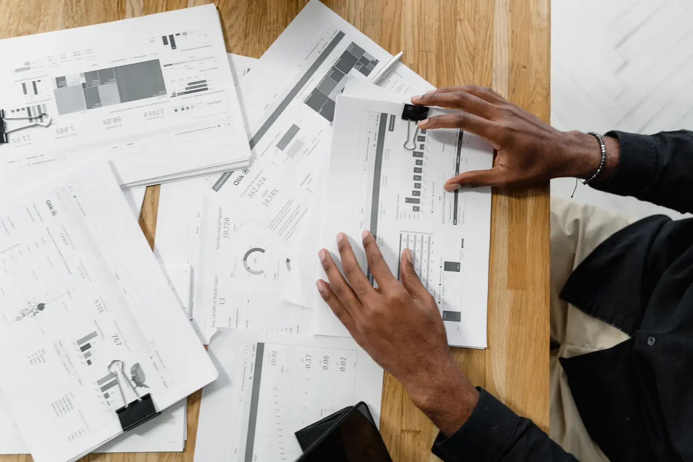 Top view of a professional reviewing financial documents, illustrating intrinsic value defined in finance