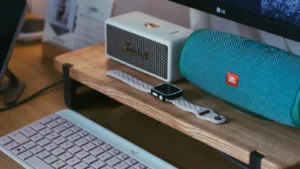 Modern workspace with Bluetooth speakers, smartwatch, and keyboard for a JBL vs Bose comparison