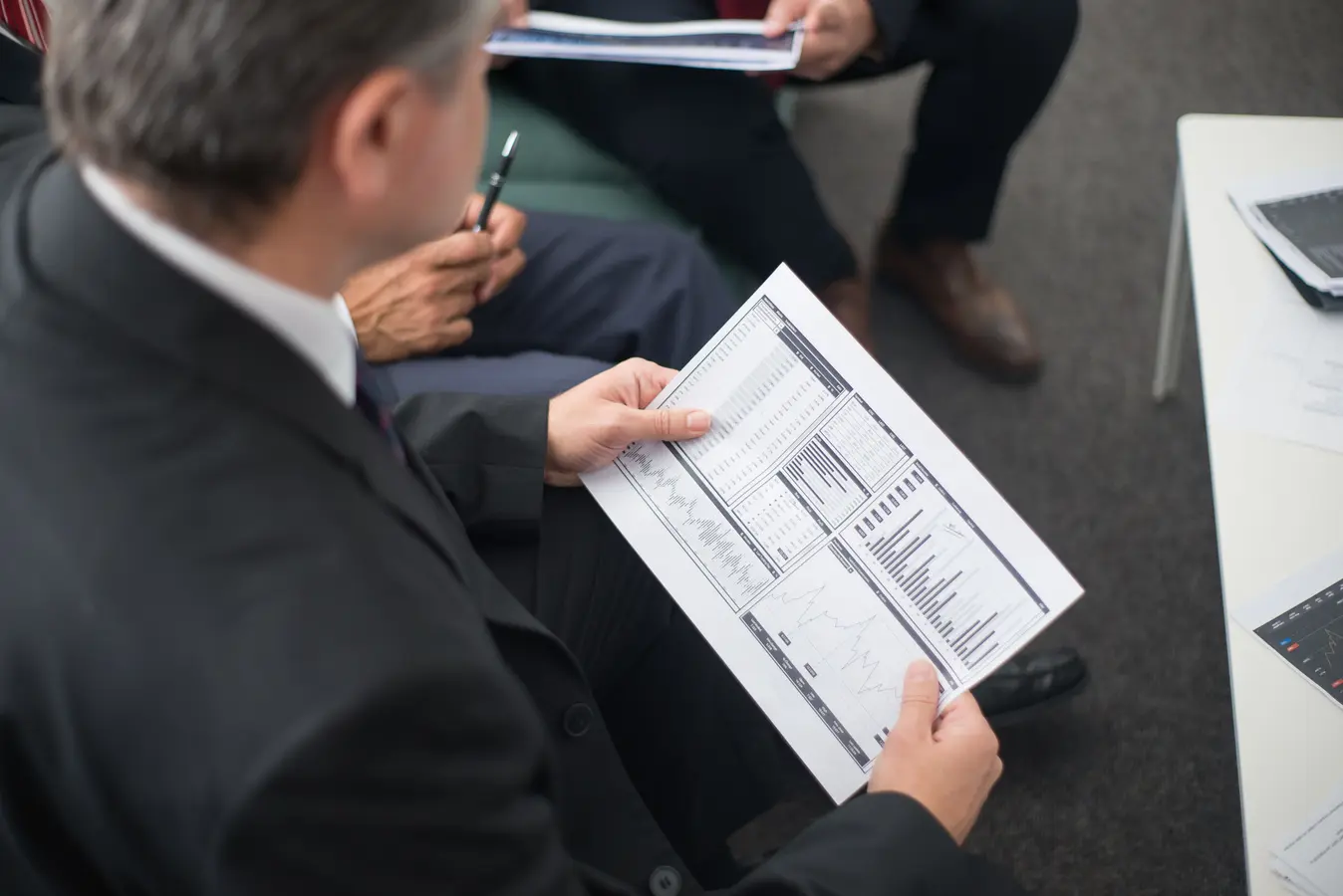 Two businessmen reviewing financial documents and data trends during a meeting on ESG investing jobs