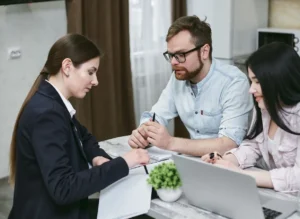 Couple reviewing financial documents with an advisor while discussing jumbo mortgage meaning