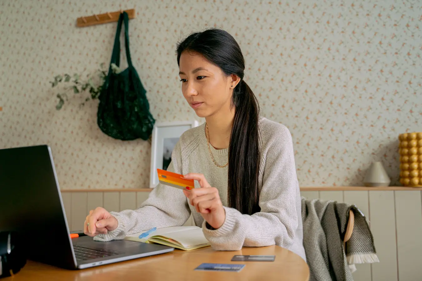 Young woman using a laptop and credit card for online shopping at home in India