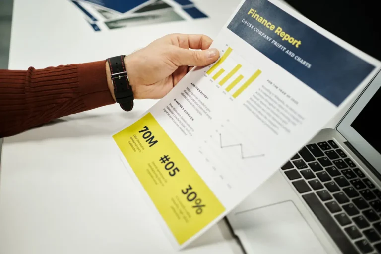 Person reviewing a finance report with graphs at a desk for meta intrinsic value analysis