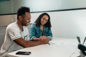 Couple reviewing mortgage documents and holding hands while discussing VA loan interest rates