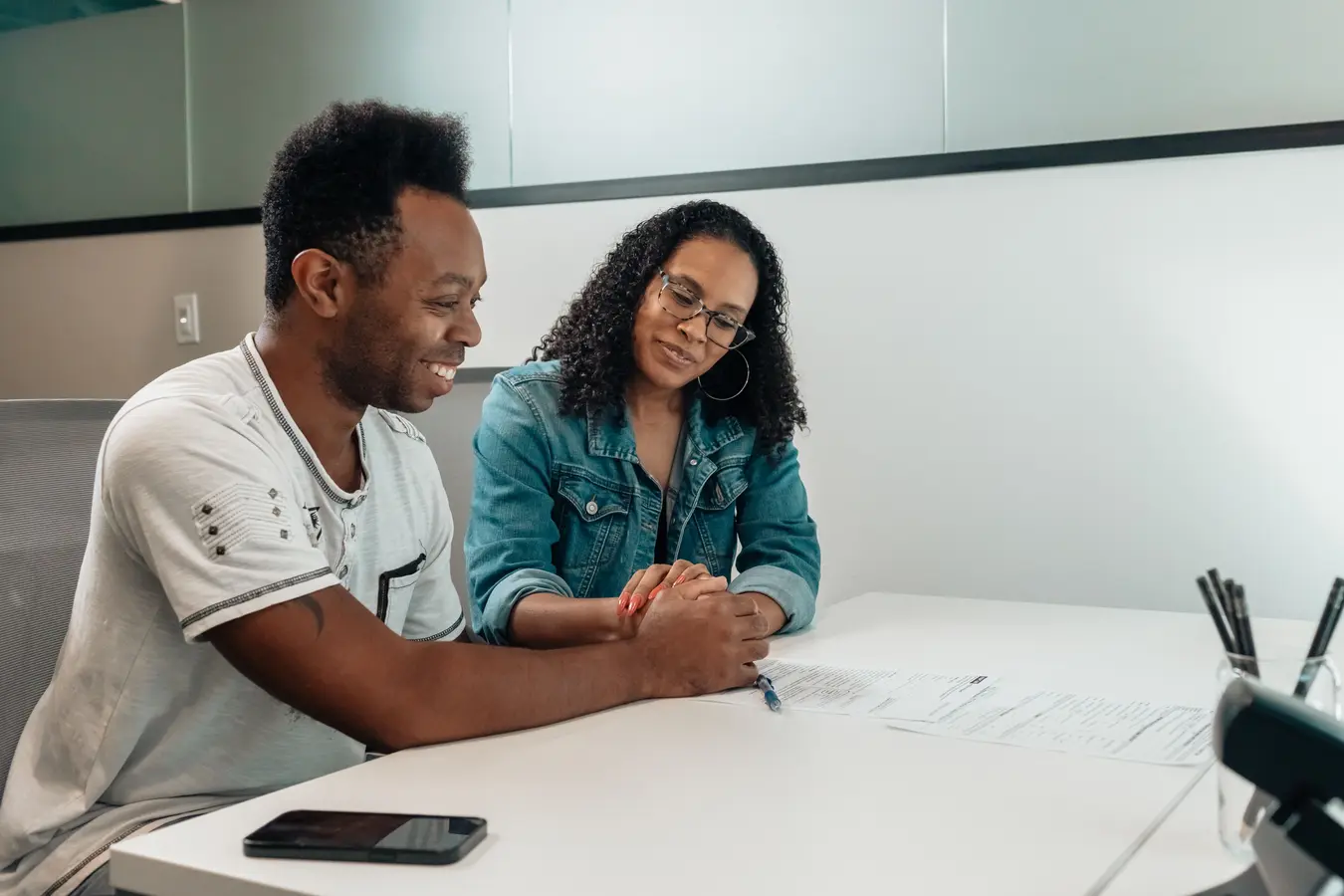 Couple reviewing mortgage documents and holding hands while discussing VA loan interest rates