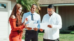 People reviewing real estate documents outside a home, illustrating mortgage LTV meaning