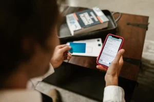 Person making an online payment on a smartphone with a credit card indoors