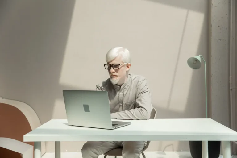 Bearded entrepreneur browsing on a netbook at a sunlit desk, troubleshooting Norton Password Manager in Chrome