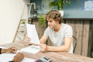 Man reviewing documents at a desk while comparing personal loans with low-interest options