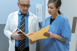Doctor and nurse reviewing patient records in a clinical setting
