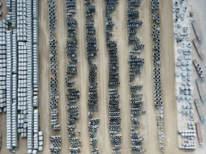 Drone view of an organized outdoor concrete manufacturing facility with stacked pipes and materials