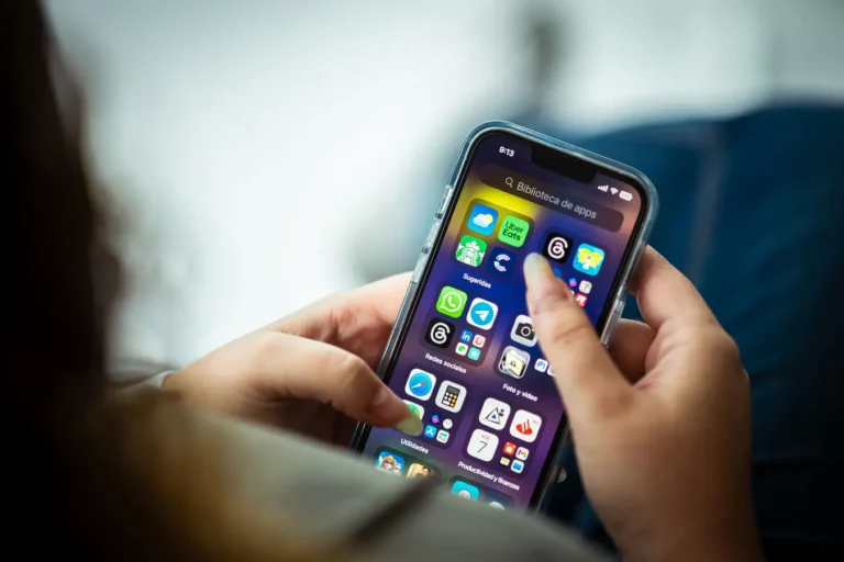 Woman holding a smartphone with app icons, relevant to Proton Pass password manager