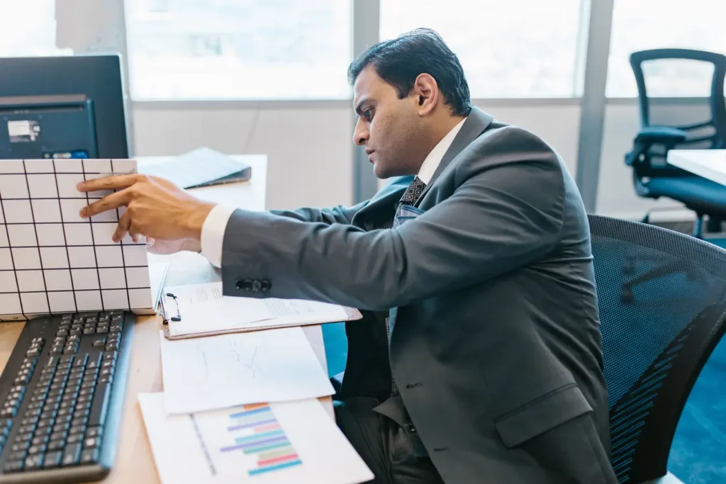 Businessman in a suit reviewing data charts at an office desk for REITs and InvITs in India