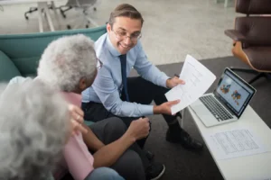 Financial advisor reviewing reverse loan mortgage documents with senior clients in an office