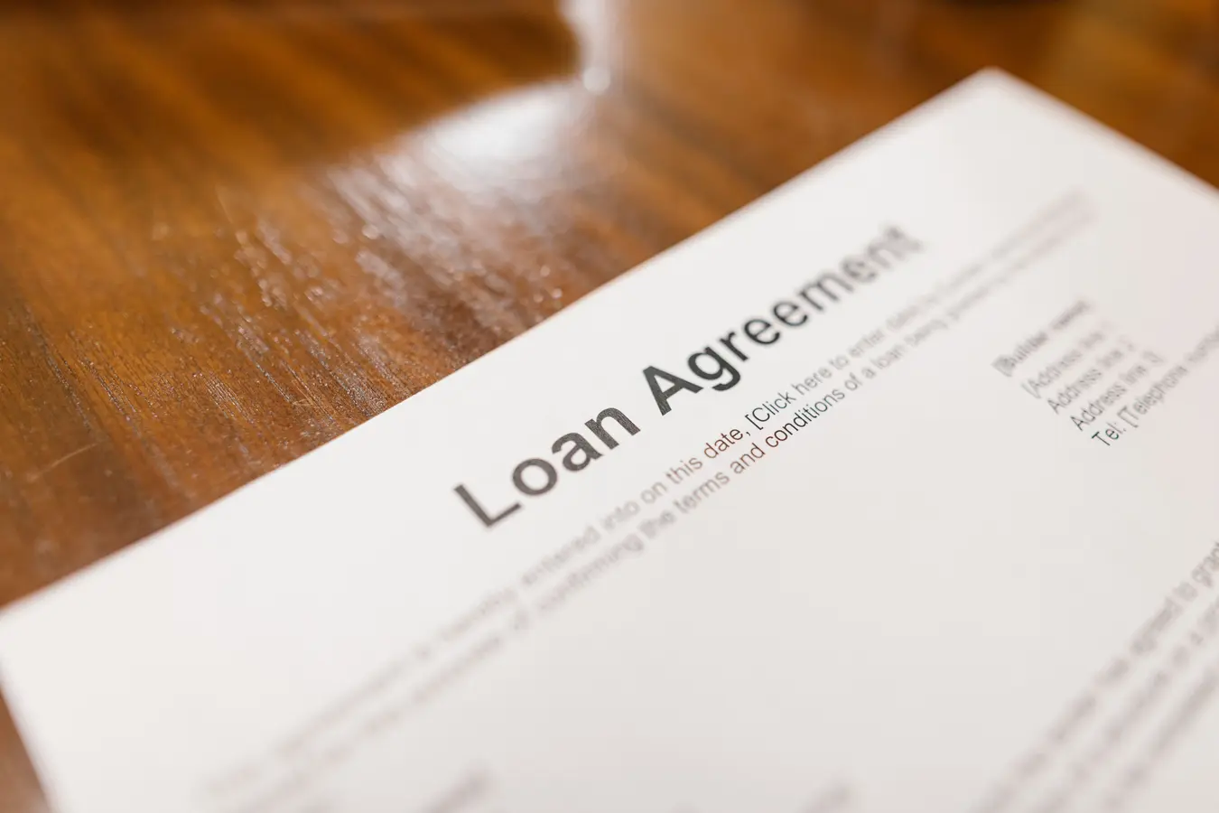 Close-up of a loan agreement document on a wooden table, illustrating subordinate mortgage meaning