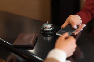Close-up of hotel check-in with smartphone and credit card payment at the reception desk