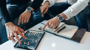 Two businessmen reviewing financial data on a tablet during an ESG investing meeting