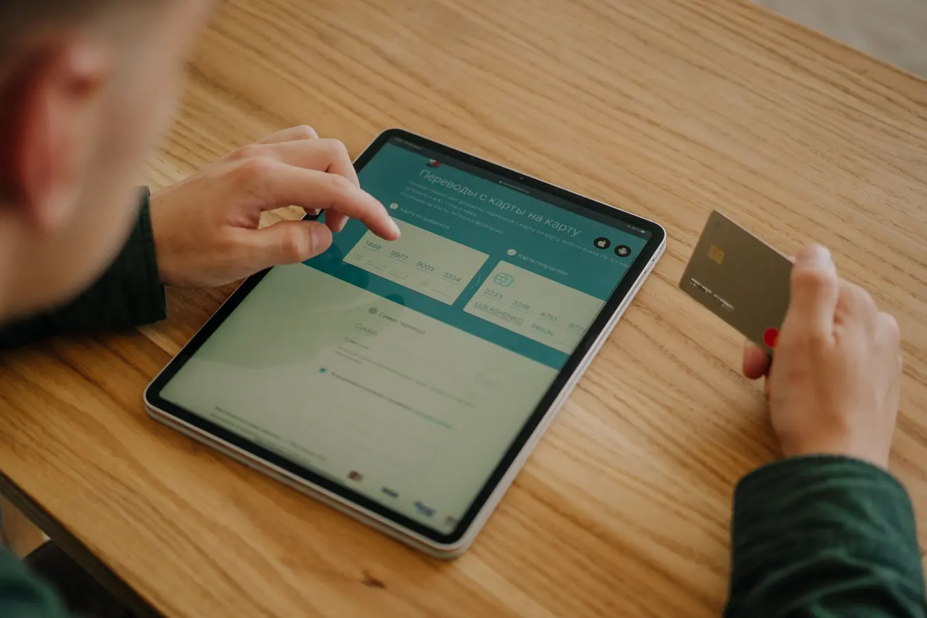 Person making an online payment with a tablet and credit card, relevant to virtual credit cards in India