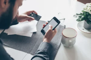 Man using a smartphone and credit card for an online banking payment